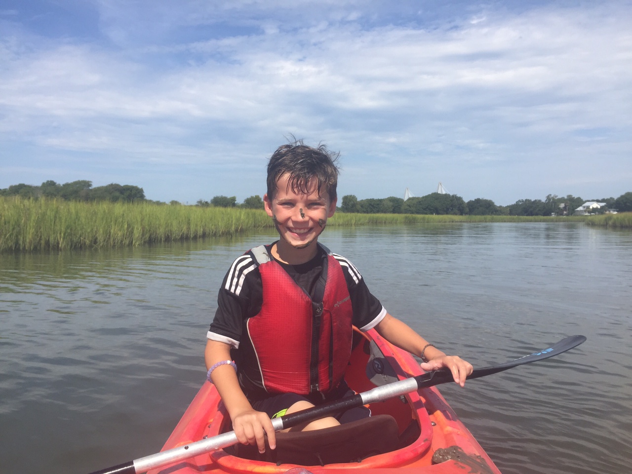 Kids Kayak in Charleston little boy wearing a life vest kayaking in Charleston, South Carolina