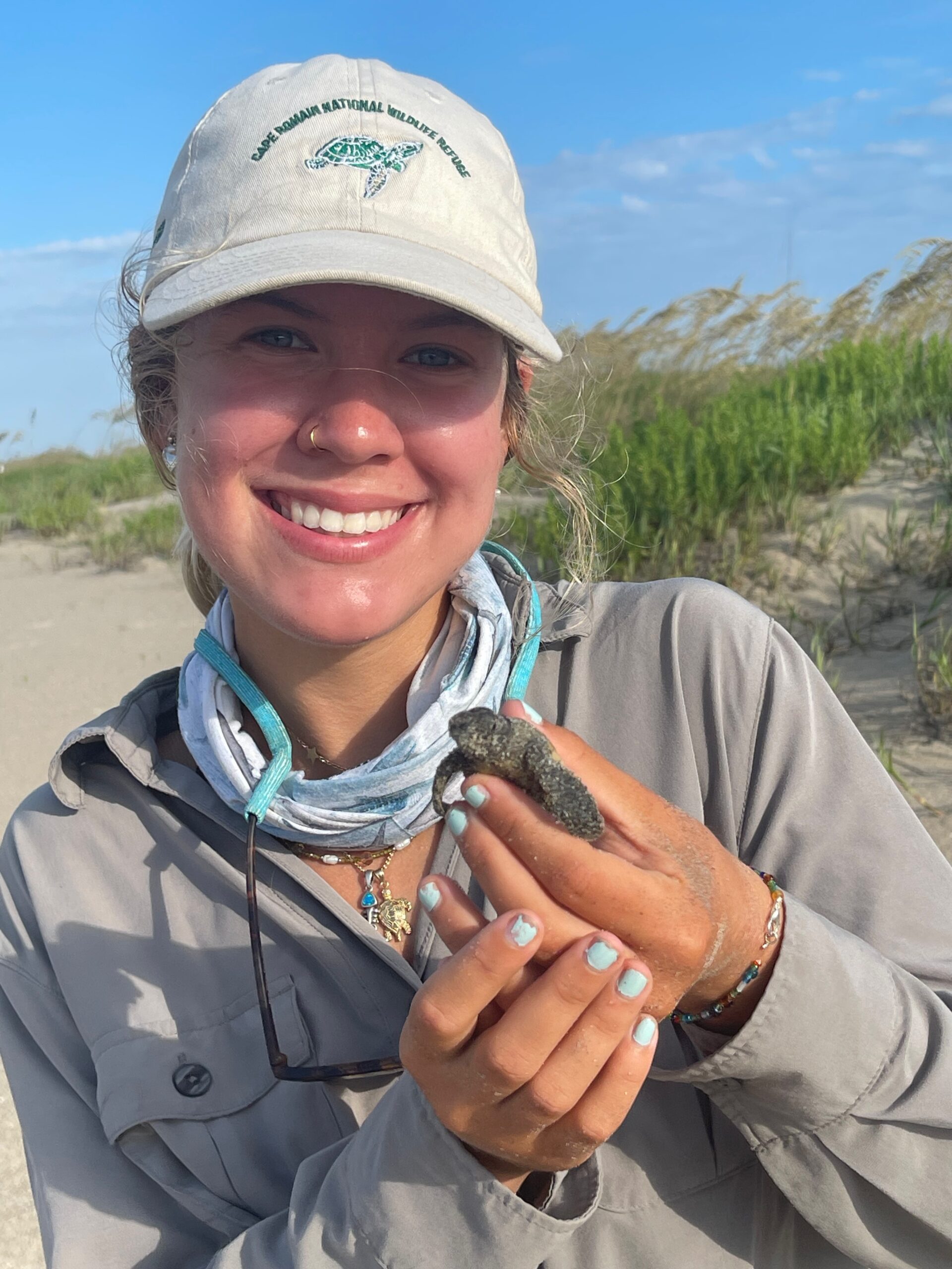 Intern Kai with a hatchling from the first nests to hatch in Cape Romain NWR (2025) Kai Hudson, Coastal Expeditions Foundation