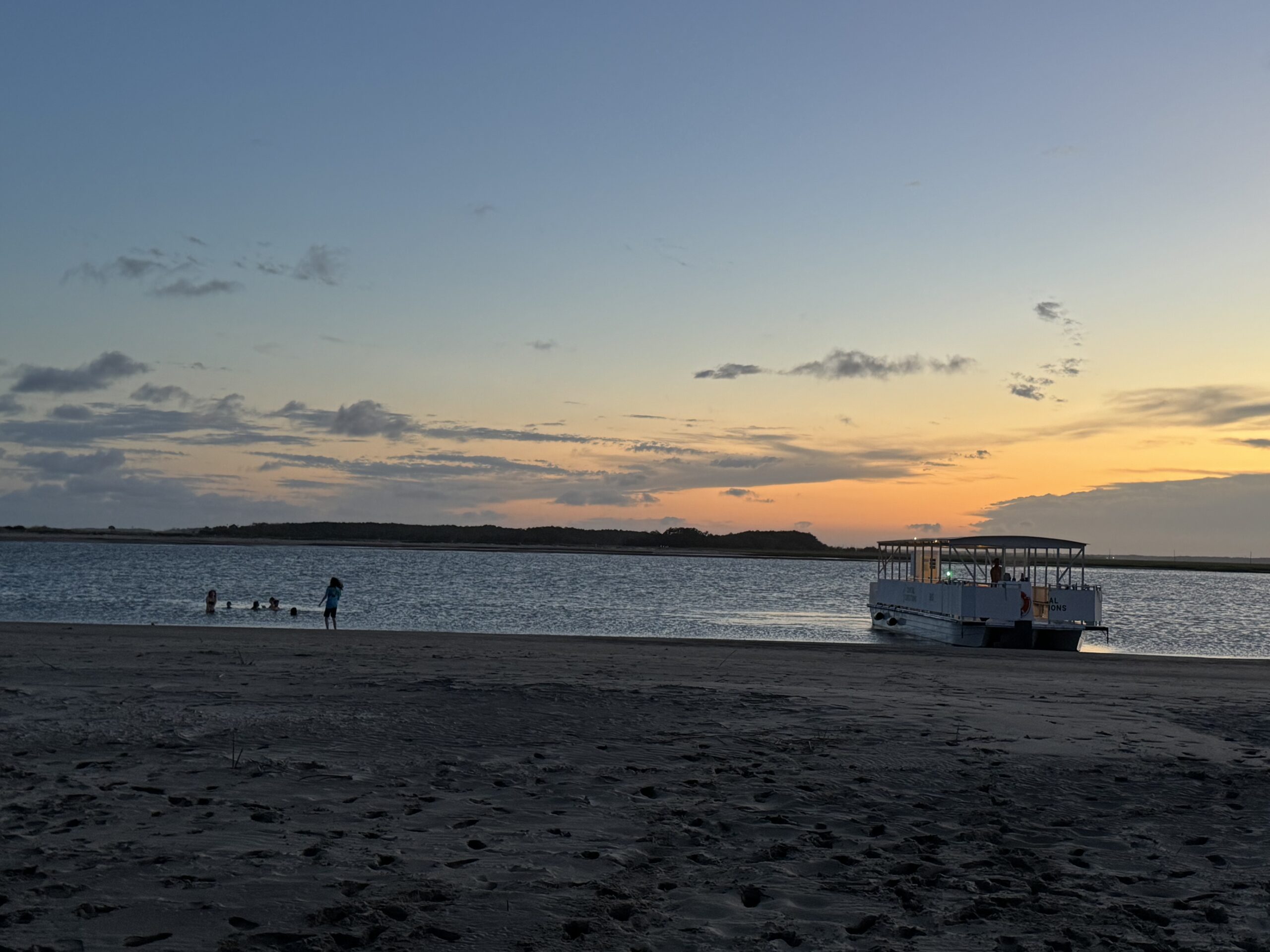 Bulls Island Ferry doing a Beach Drop at sunset with people swimming nearby